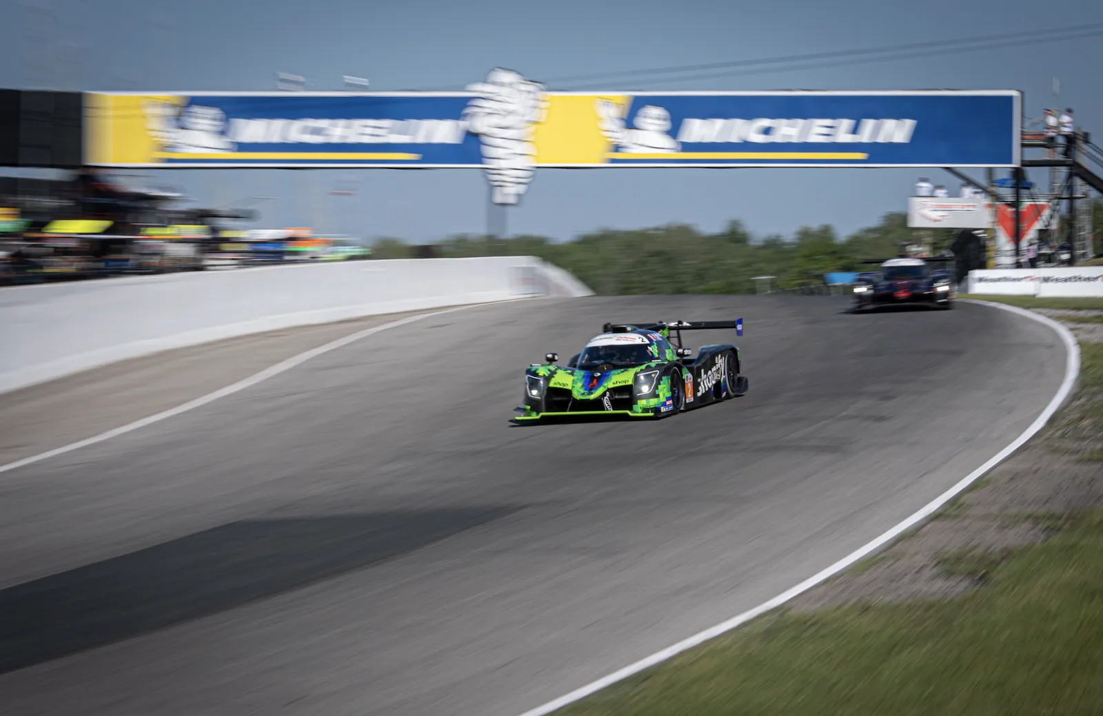 The number 2 Shopify Racing Ligier LMP3 at speed under the Michelin bridge at Canadian Tire Motorsport Park